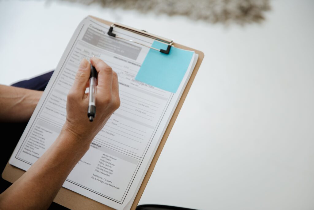 Hand füllt einen Fragebogen aus