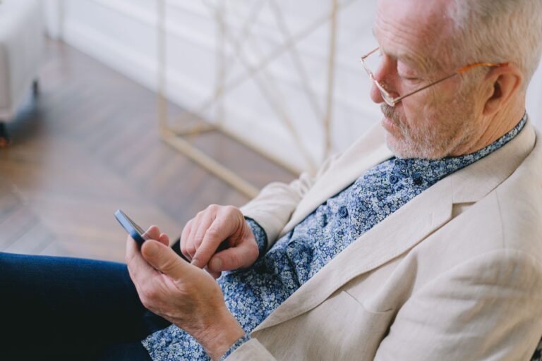 Älterer Mann mit Brille benutzt ein Smartphone