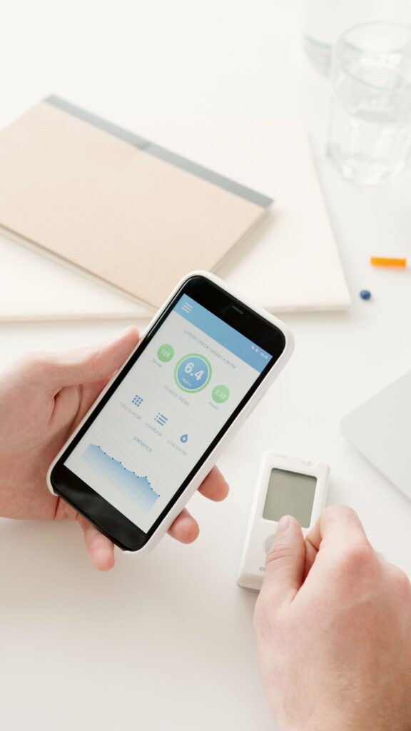 Hände nutzen eine Gesundheits-App mit einem digitalen Messgerät